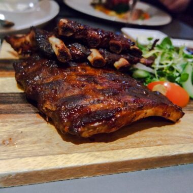 Spareribs on the cutting board in the restaurant. Spareribs on the cutting board in the restaurant.